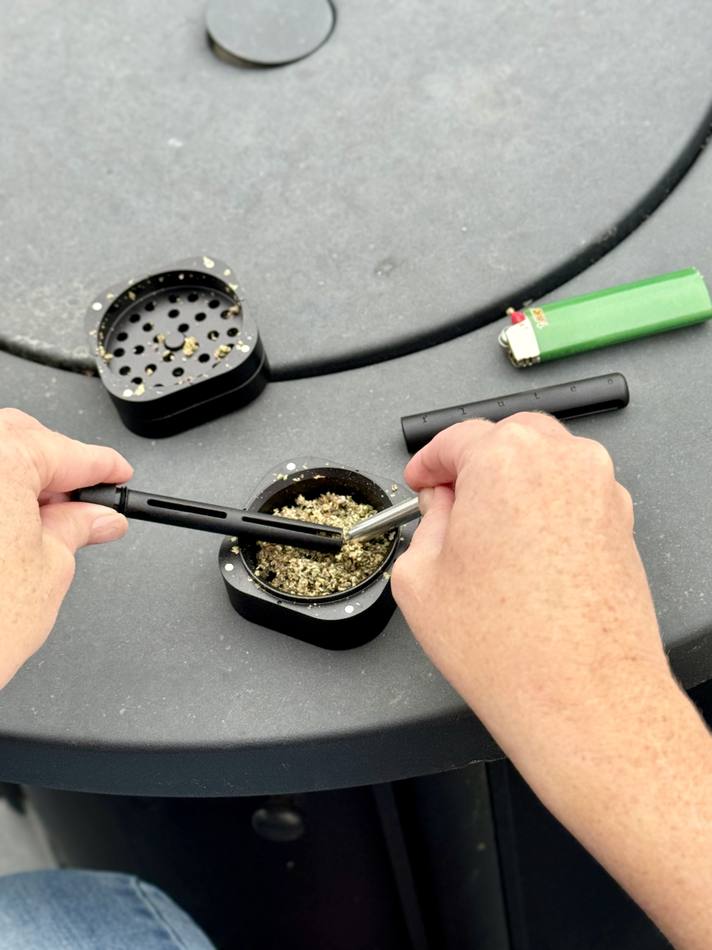 Scooping the half-gram bowl full from a grinder